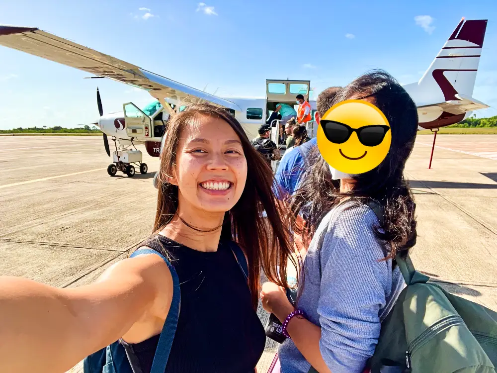 The blog author smiling and taking a selfie with a small plane in the background.