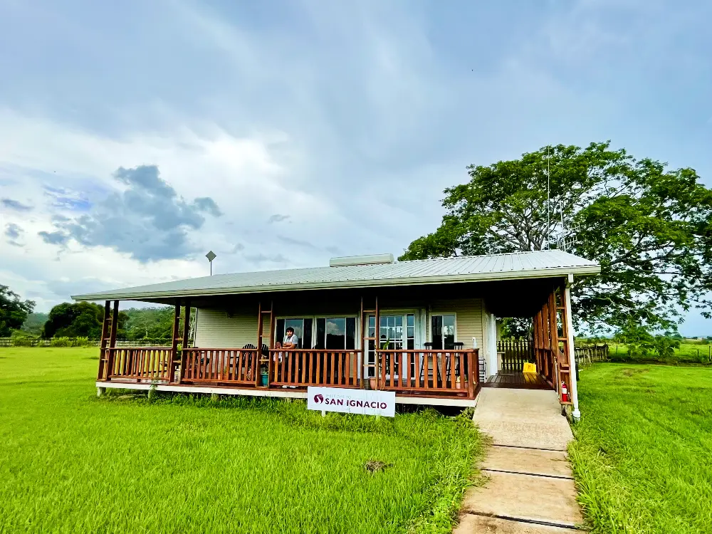 A small building with the sign that says "San Ignacio", surrounded by green grass.