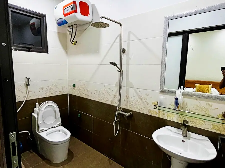 A simple bathroom with a shower head that doesn't have a stall or tub.