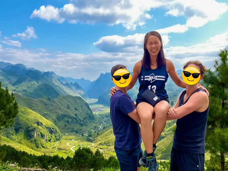 The blog author wearing shorts and tanks with a mountain view in the background.