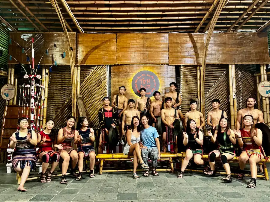 A couple sitting in front of a group of performers wearing show costumes.