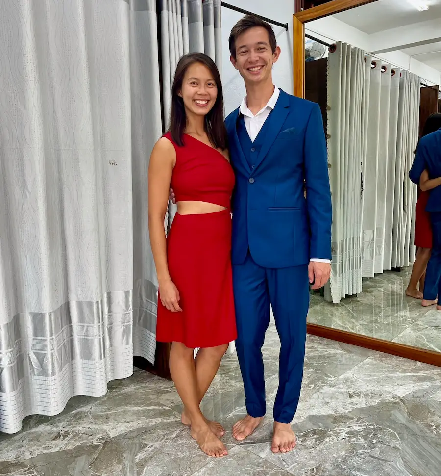 A couple wearing a tailored red dress and blue suit.