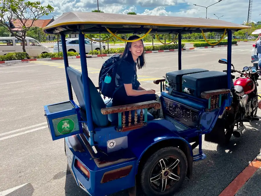 The blog author sitting on a big-sized tuk-tuk carrying luggage.