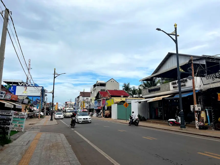 A street lined with small businesses and some motorbikes on it.