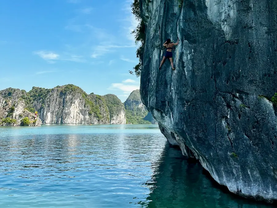 The blog author holding onto the side of a limestone rock 15 feet high over water.