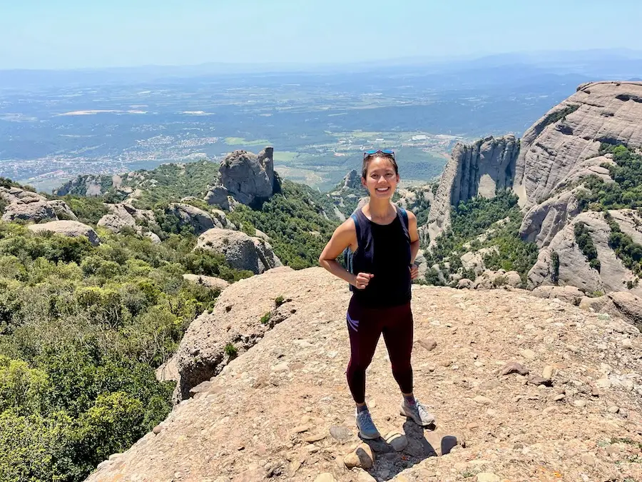 The blog author standing on a mountain with a valley view in the background.