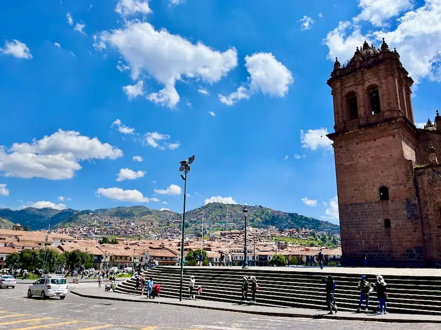 A small town with an old building and mountains in the background.