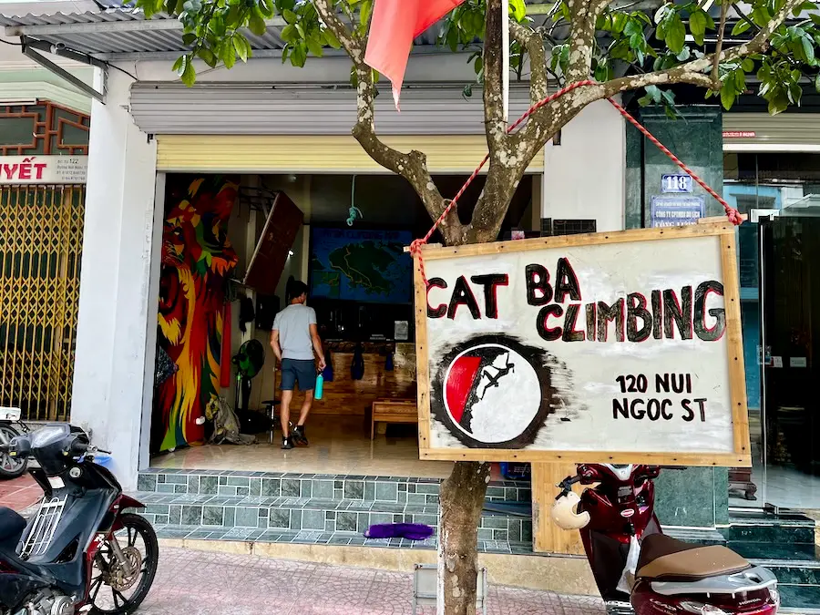 A sign outside a shop that says "Cat Ba Climbing 120 nui ngoc st"