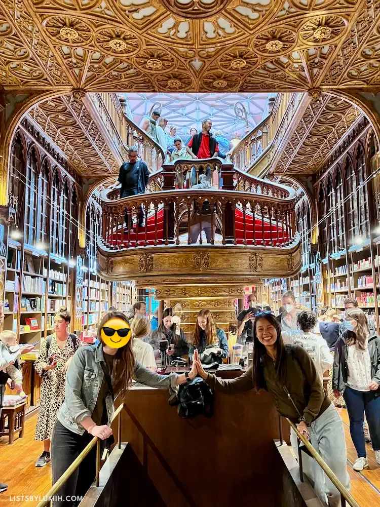 The interior of an intricate bookstore with a golden staircase and ceiling.