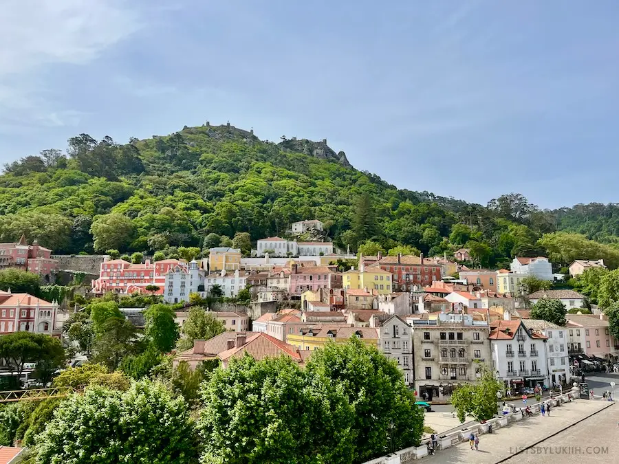 Colorful houses at the bottom of a green, lush mountain.