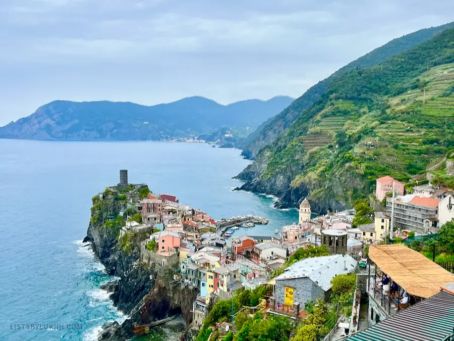 Colorful houses on a mountain cliff sticking out into the ocean.