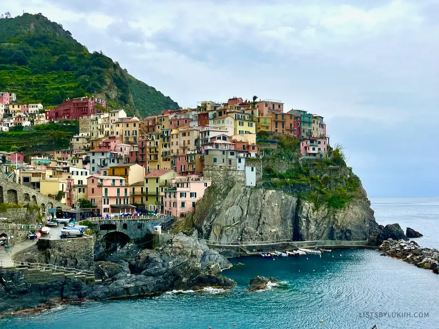 Colorful houses on a mountain cliff by the ocean.