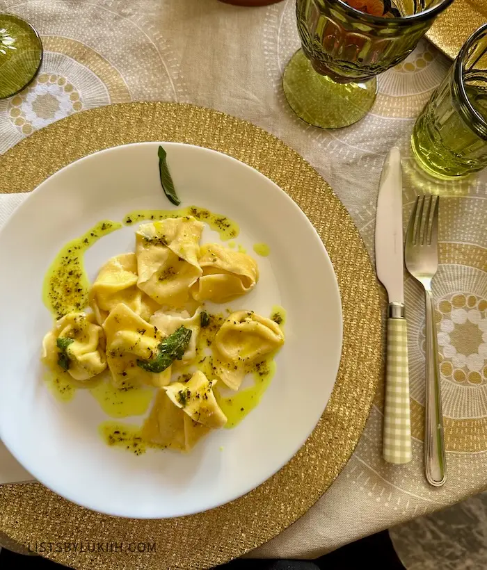 A plate of tortellini with some spice and oil.