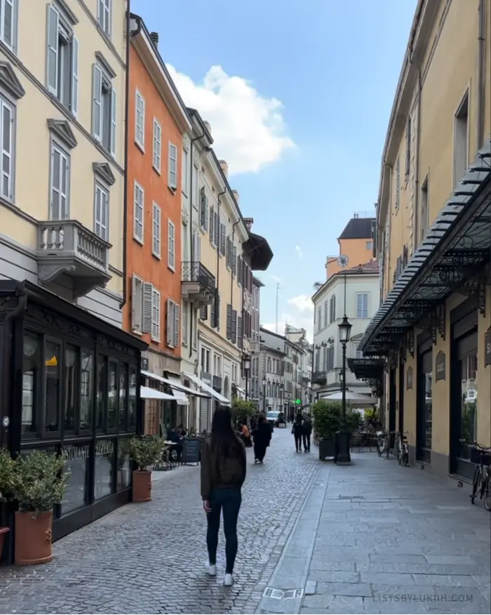 A woman walking through an European, narrow street.