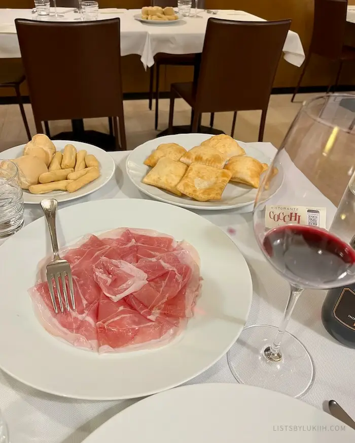 Thin cured ham sitting on a plate.