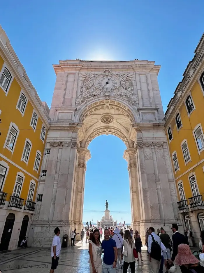 A white arch leading to an open plaza.