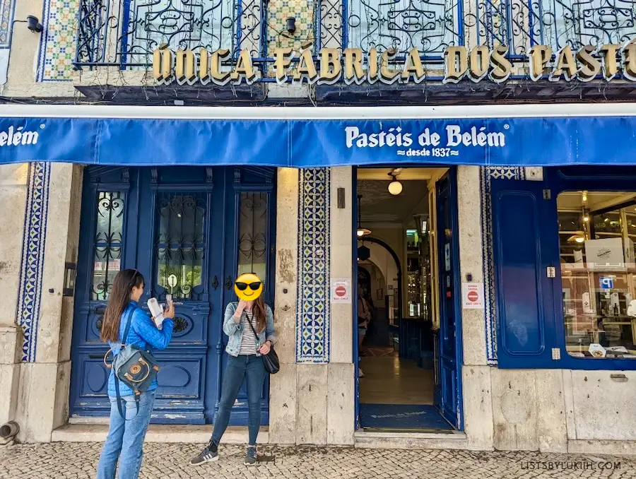 Two women standing outside a store that says Pasteis de Belem.