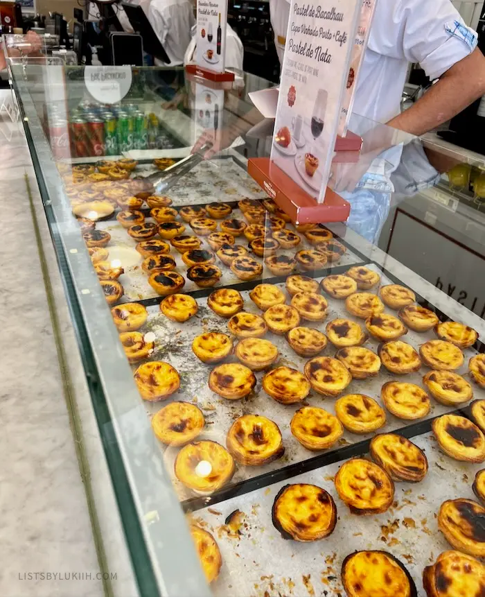 A display window selling multiple custard tarts with charred tops.