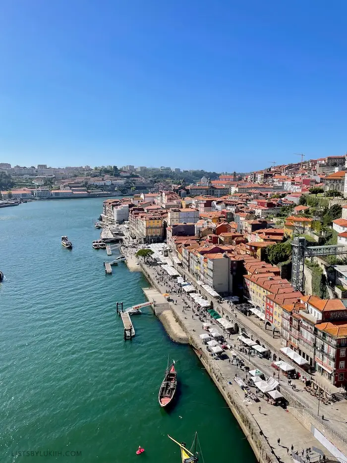 Buildings with orange rooftops lining a river.