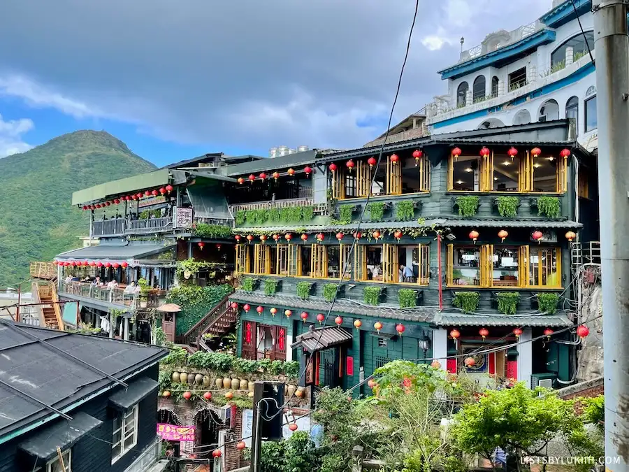 A building decorated with lanterns nestled in a mountain.