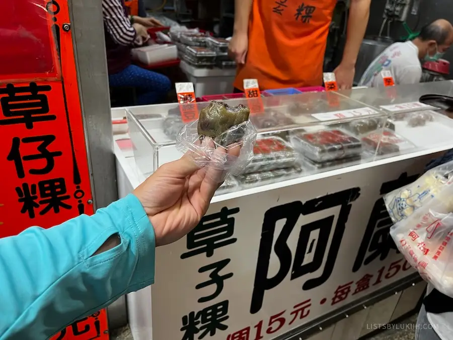 A hand holding a chewy snack with red bean inside.