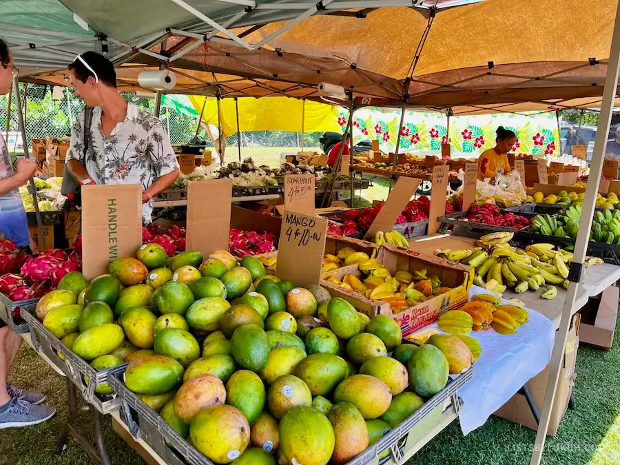 An open-air market selling fruits like mango and banana.