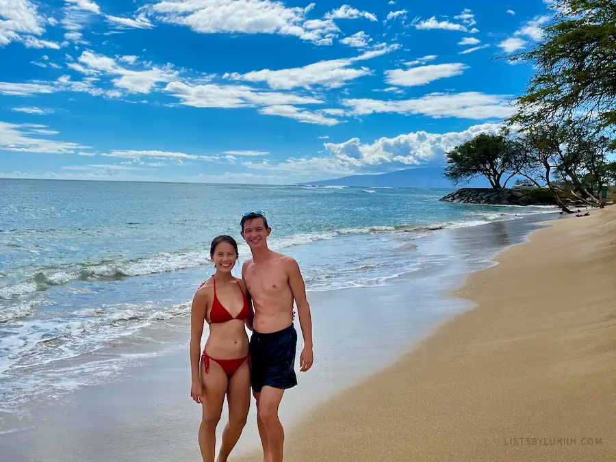 A couple holding on a sunny beach.