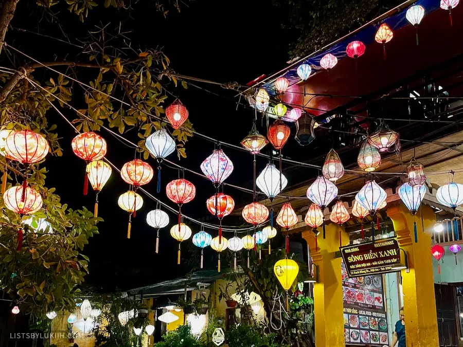 A street decorated with brightly-lit lanterns at night.