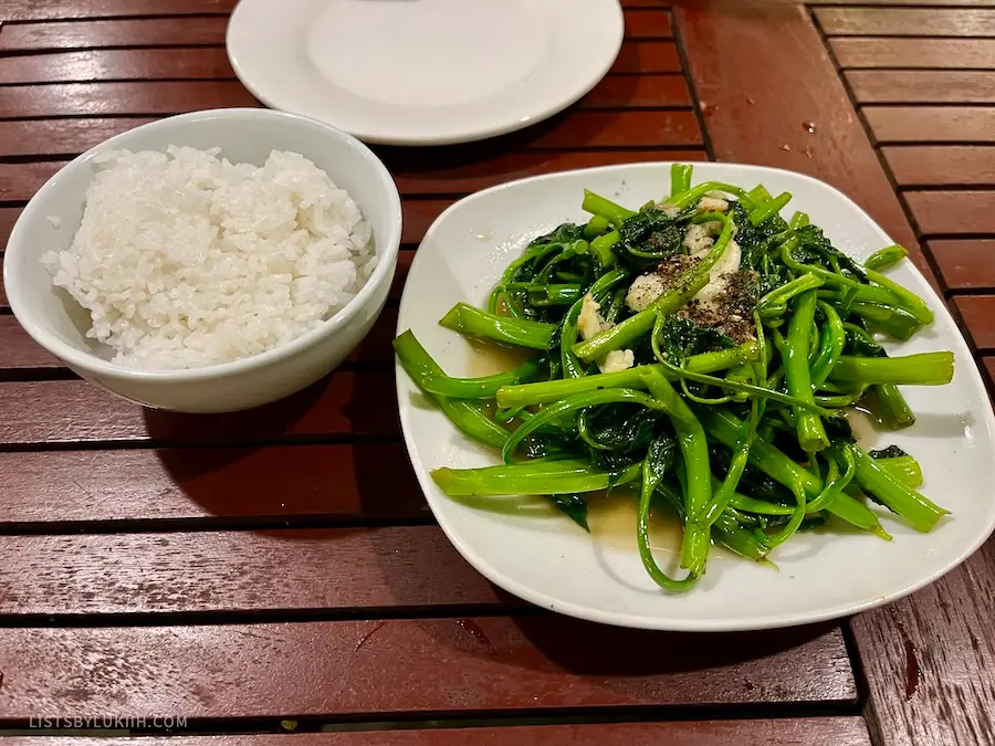 A plate of vegetable served with rice and garlic.