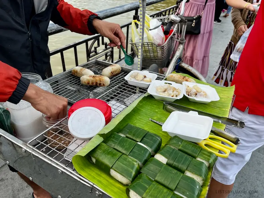 Sticky rice wrapped in bamboo leaves, being served on the streets.