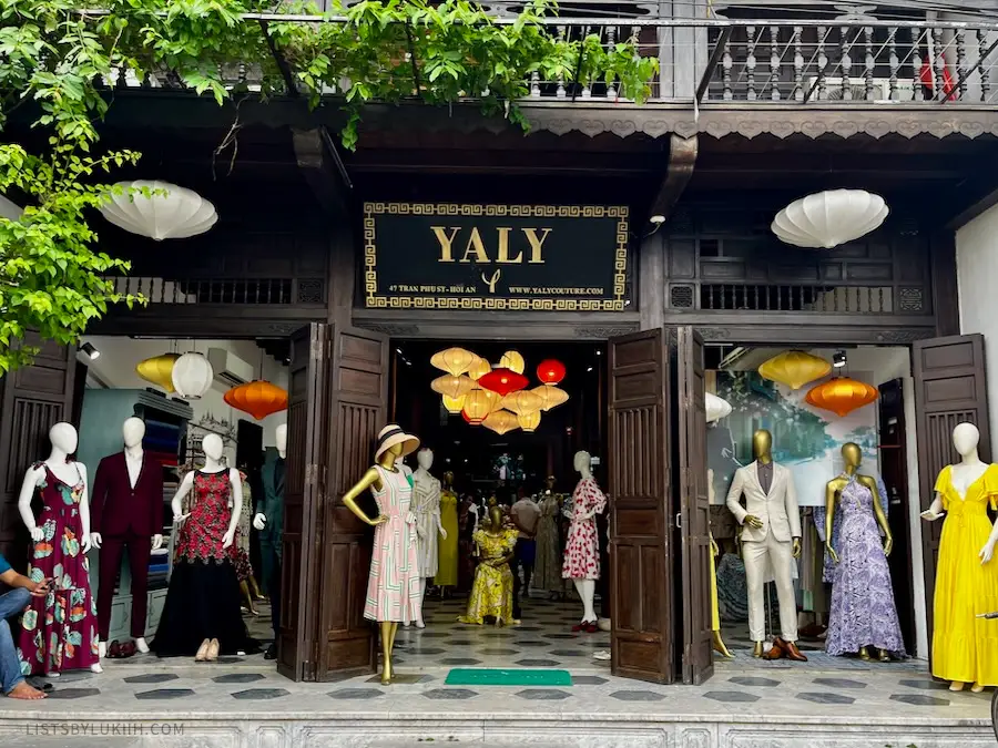 A store front with mannequins dressed in suits and dresses.