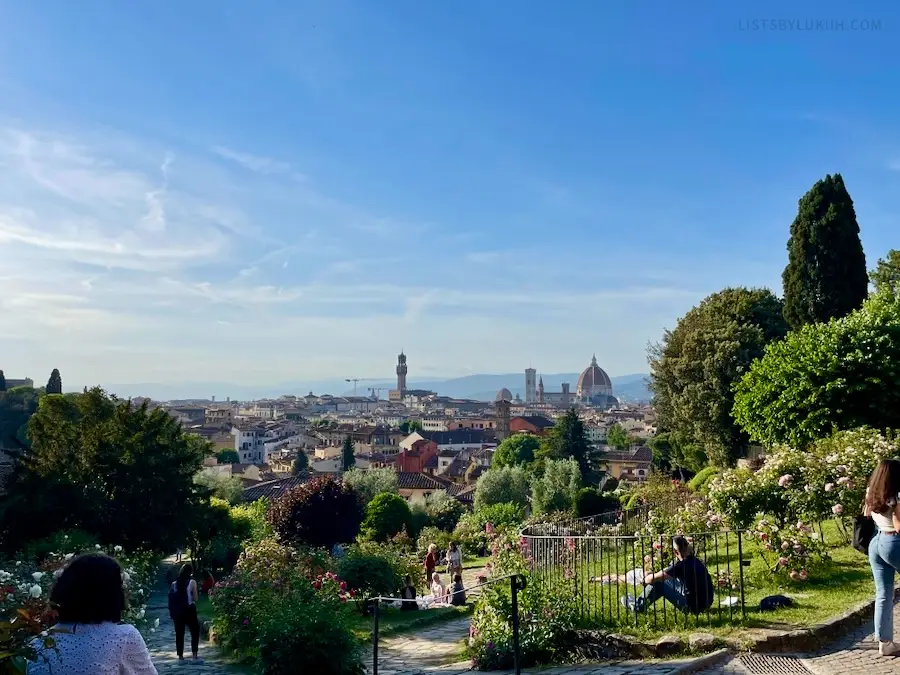 A view from up a hill with lots of gardens.