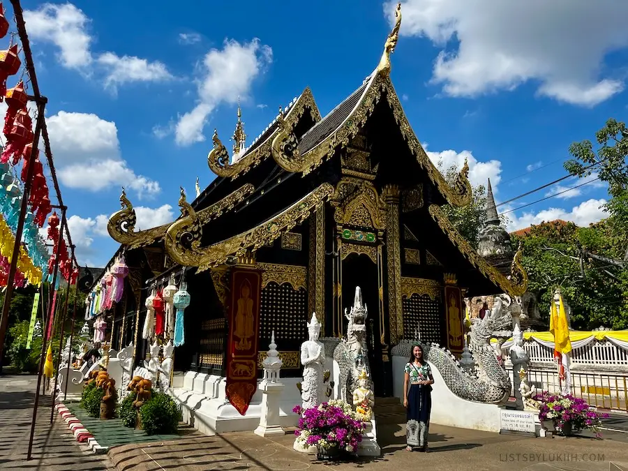An intricate Buddhist temple with two dragon sculptures at its entrance.