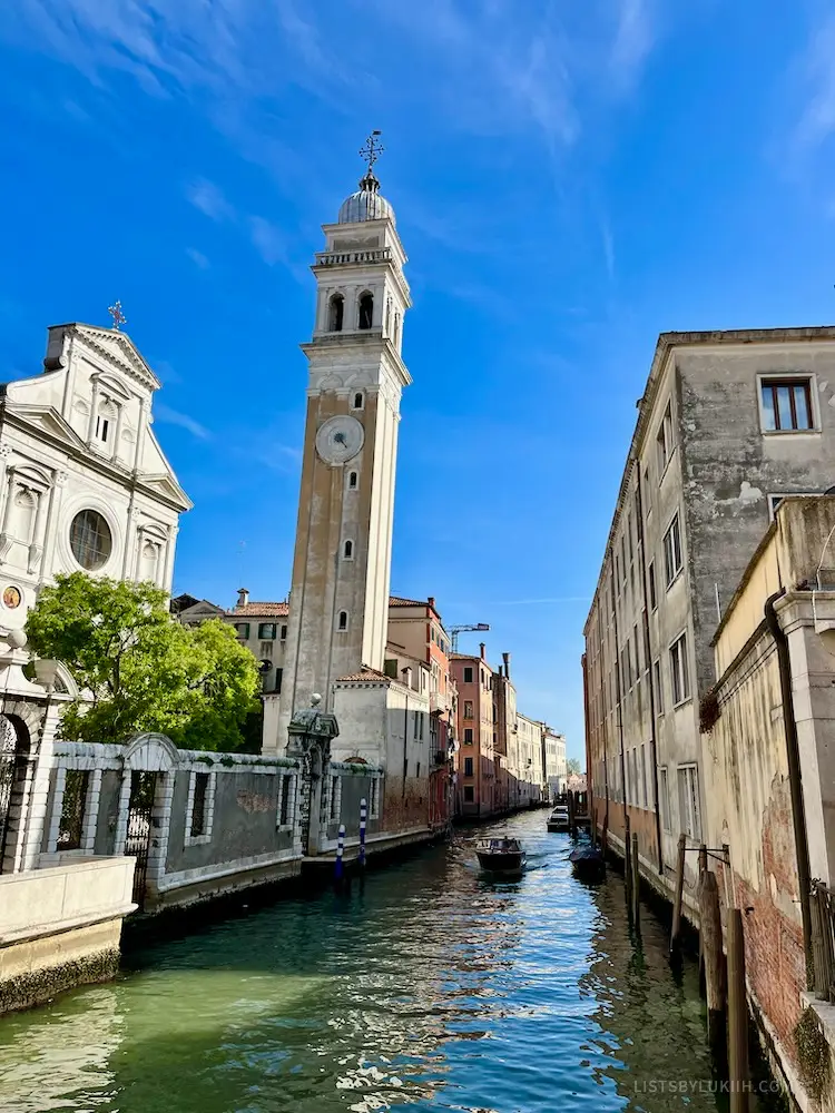 A canal with a tall tower next to it.