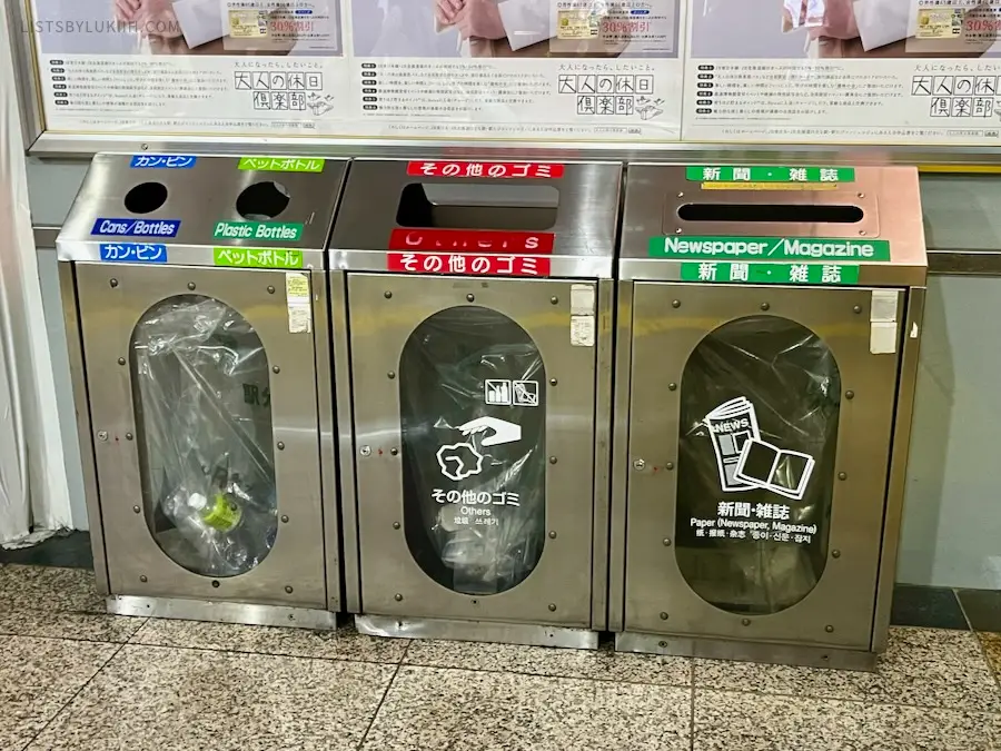 Three trash cans with different labels of the type of trash.
