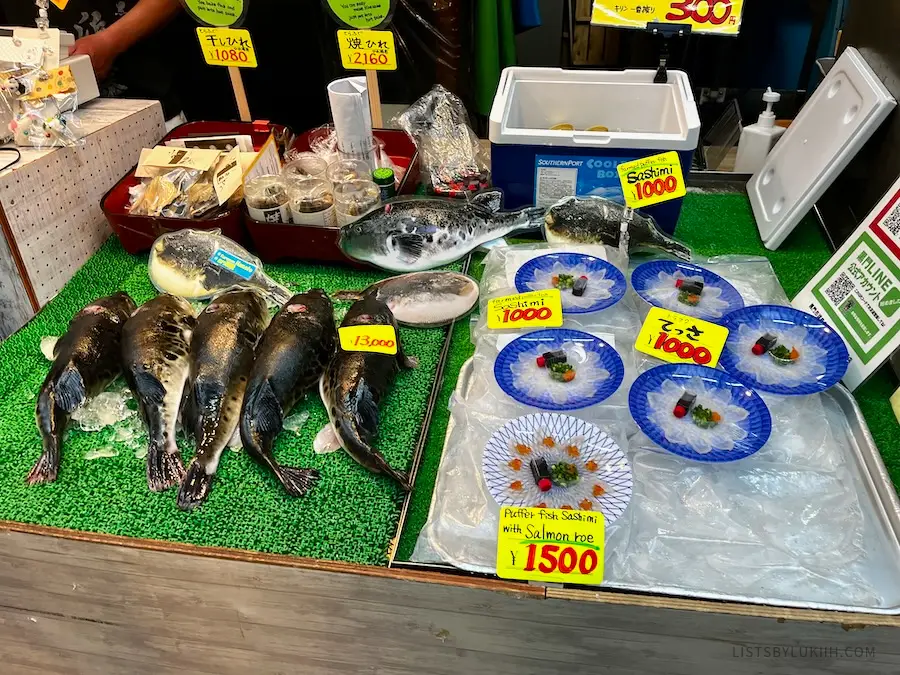 Black fish next to thinly-sliced white raw fish.