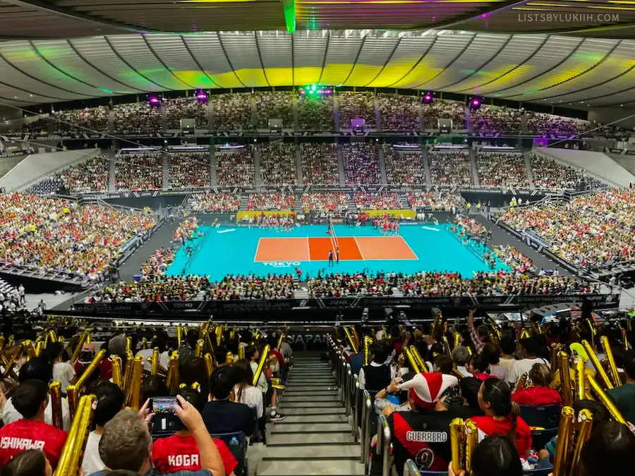 A full sports stadium with a volleyball court at the center.