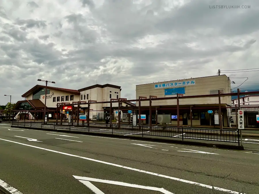 A train and bus station with Japanese sign on it.