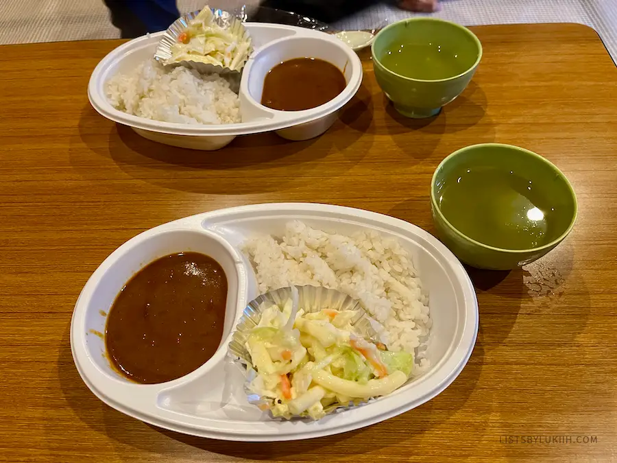 Simple Japanese curry and rice on plastic bowls with tea.