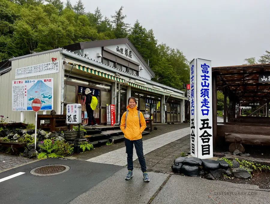 A hiker standing in front of a shop with Japanese letters on it.
