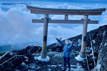 A woman next to a Shinto shrine above the clouds.
