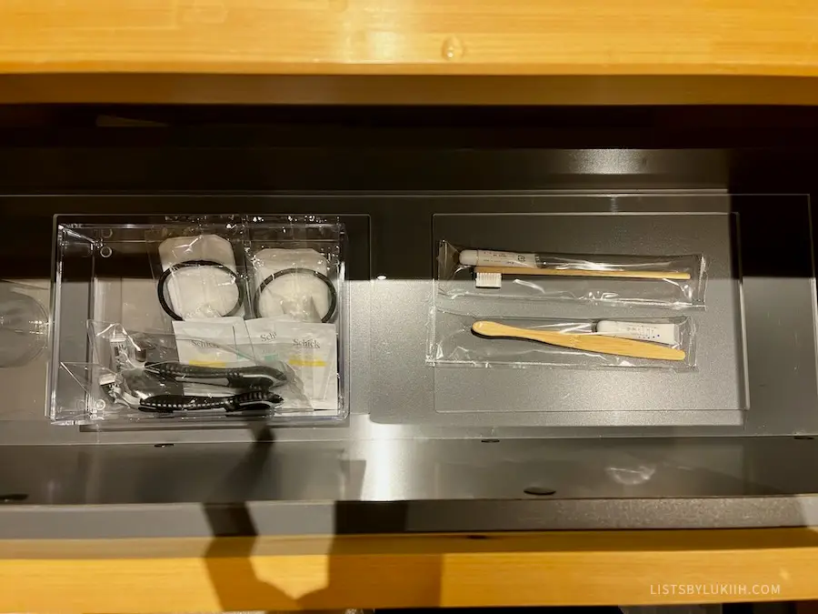 A set of toiletries, including toothbrushes, in a drawer.