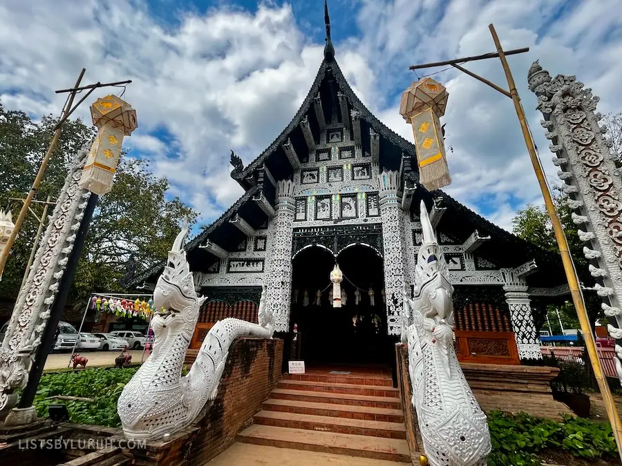 A white and black temple with dragon-like statues at the entrance.