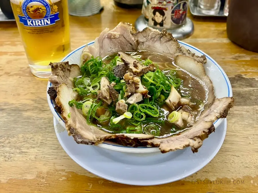A bowl with marbled pork, noodles, and mushrooms.
