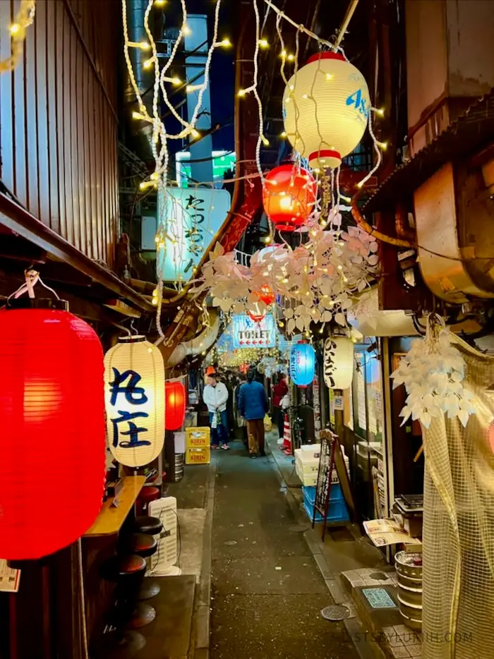 A narrow streets decorated with lights.
