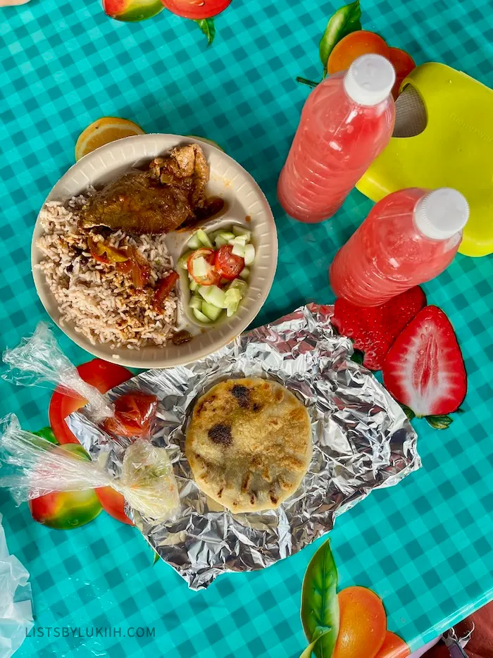 A plate of chicken and rice and pupusa with watermelon juices in bottled plastic.
