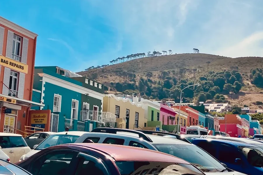 A set of colorful buildings with a mountain in the background.