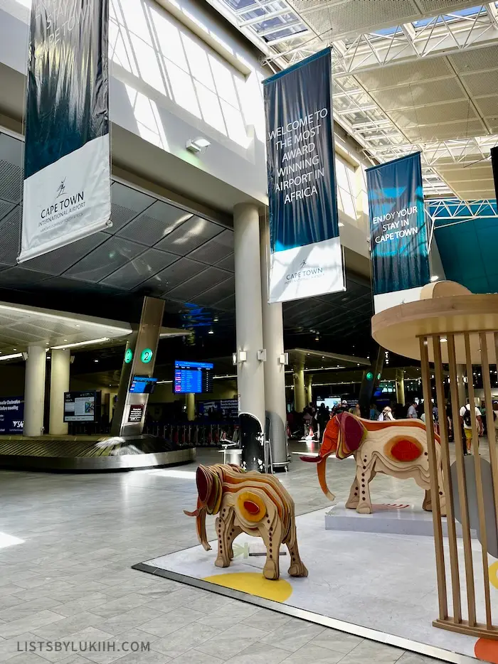 Interior of an airport featuring wooden elephant statues.