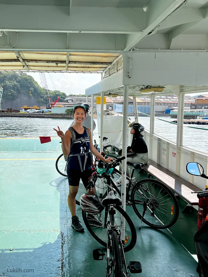 A woman staanding with a bike on a boat.