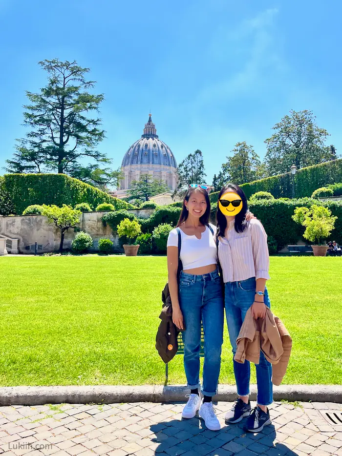 Two women standing outside with an ancient dome in the background.